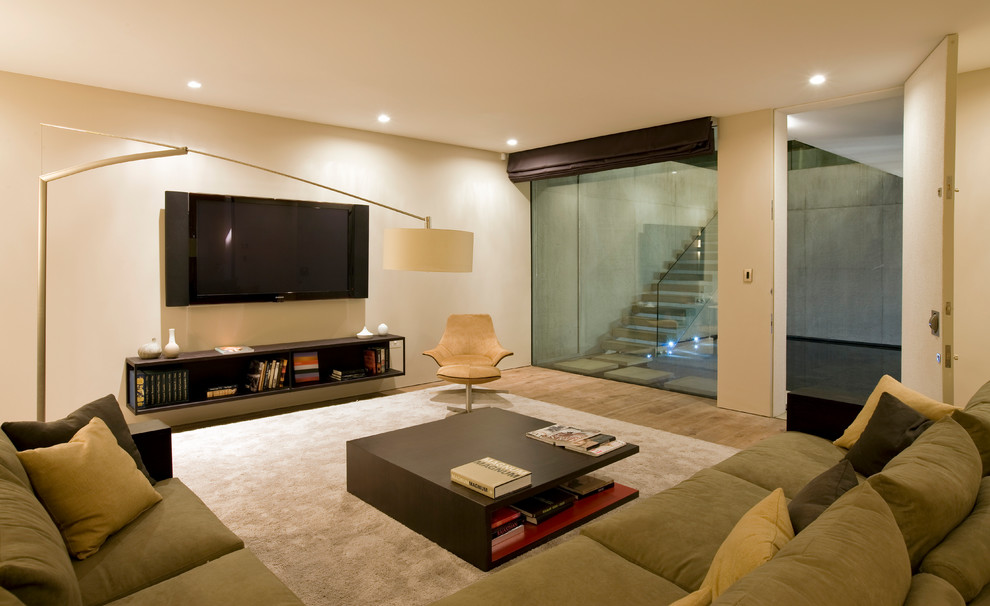 Photo of a mid-sized modern basement in London with beige walls, light hardwood floors and brown floor.