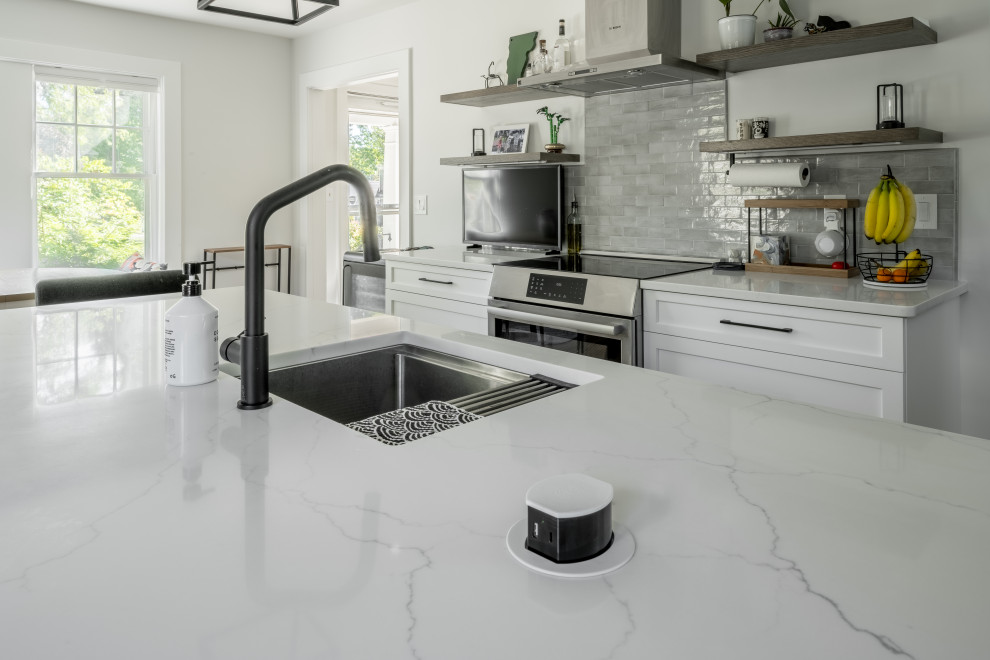 Inspiration for a large contemporary l-shaped medium tone wood floor and brown floor eat-in kitchen remodel in Boston with an undermount sink, shaker cabinets, gray cabinets, quartz countertops, gray backsplash, ceramic backsplash, stainless steel appliances, an island and white countertops