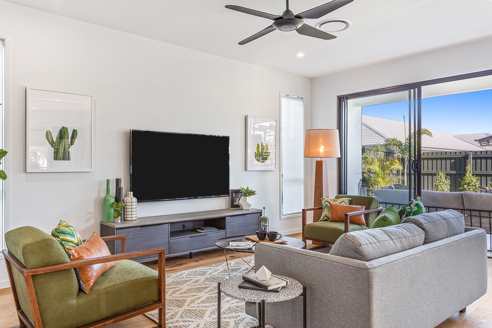 Contemporary formal living room in Brisbane with white walls, light hardwood floors, a wall-mounted tv and brown floor.