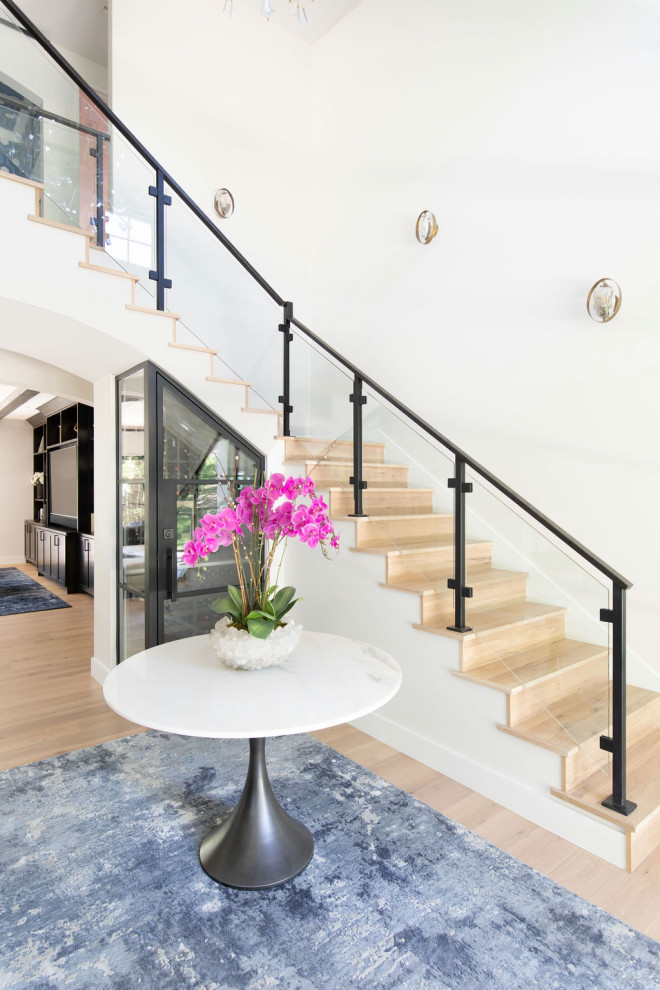 Example of a large transitional light wood floor foyer design in Austin with white walls and a black front door