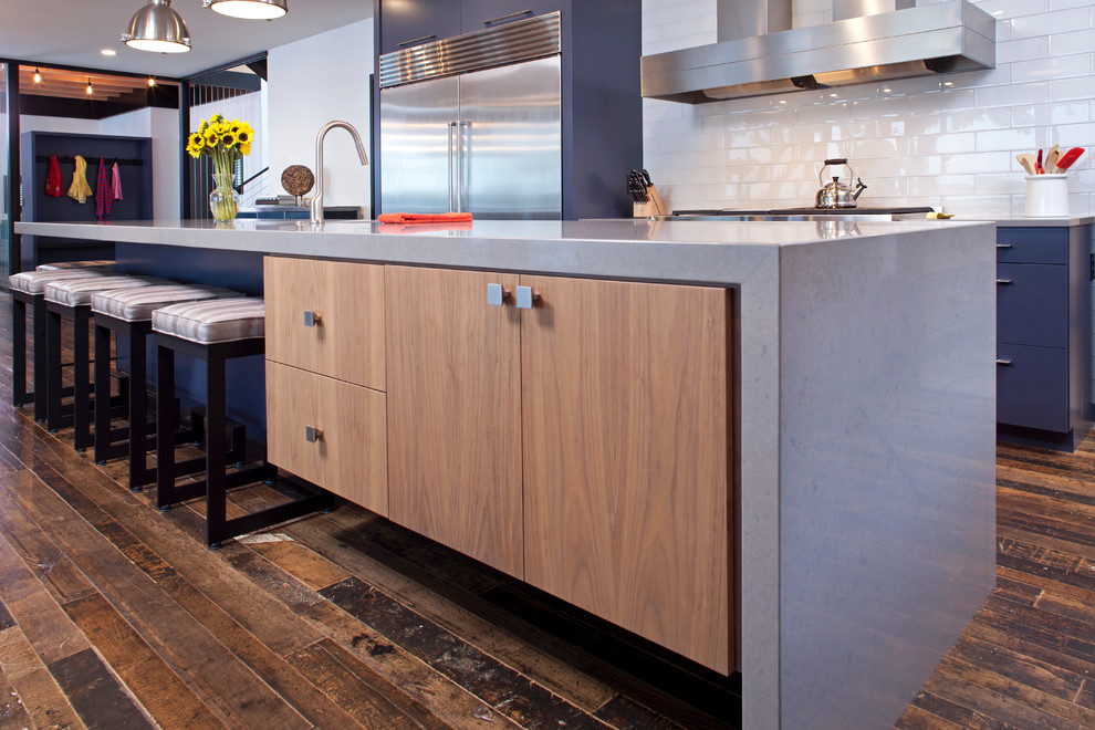 Photo of a contemporary u-shaped eat-in kitchen in Minneapolis with an undermount sink, medium wood cabinets, quartzite benchtops, white splashback, subway tile splashback, stainless steel appliances, medium hardwood floors and with island.