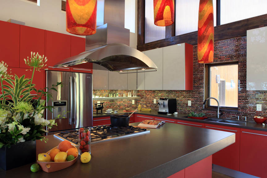 Photo of a large contemporary l-shaped open plan kitchen in Denver with an undermount sink, flat-panel cabinets, red cabinets, quartz benchtops, multi-coloured splashback, glass tile splashback, stainless steel appliances, light hardwood floors and with island.