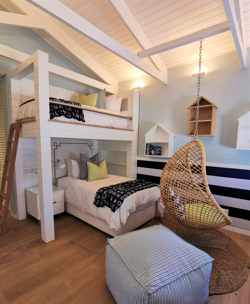 Ejemplo de habitación de invitados costera grande sin chimenea con suelo marrón, vigas vistas y papel pintado