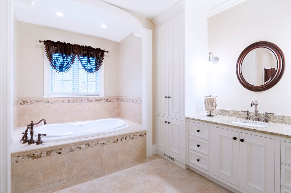 Inspiration for a mid-sized transitional master bathroom in Providence with recessed-panel cabinets, white cabinets, a drop-in tub, white walls, an undermount sink, granite benchtops, an alcove shower, beige tile, travertine floors, porcelain tile, beige floor and a shower curtain.