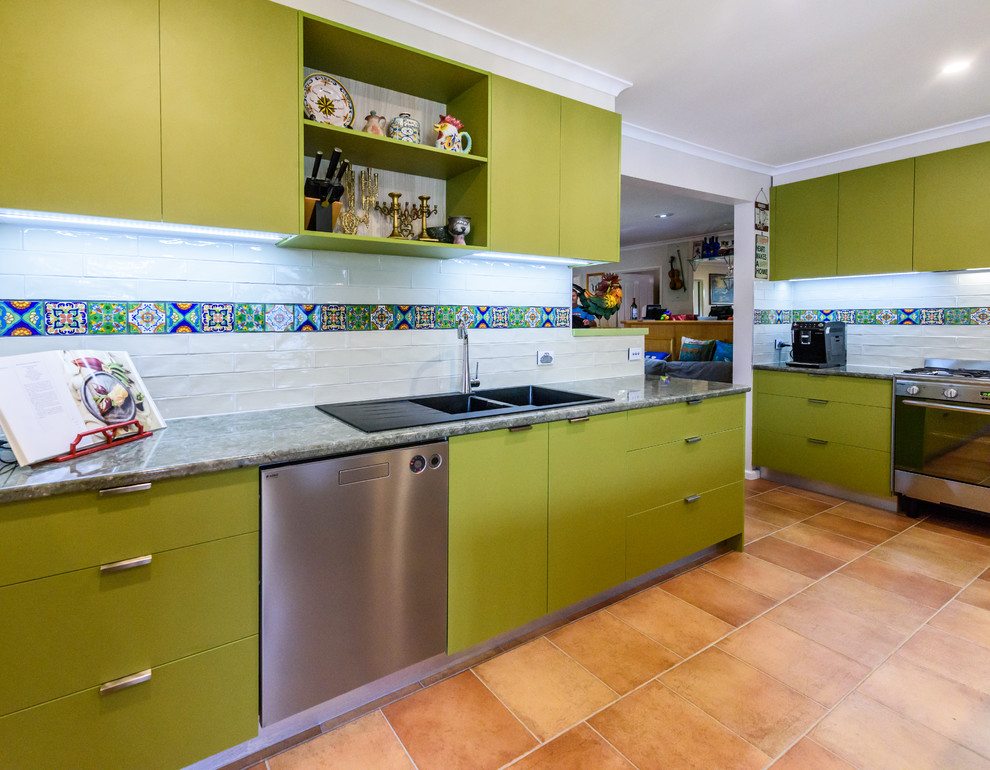 Design ideas for a mid-sized contemporary l-shaped separate kitchen in Melbourne with a double-bowl sink, flat-panel cabinets, green cabinets, laminate benchtops, beige splashback, subway tile splashback, stainless steel appliances, terra-cotta floors and with island.