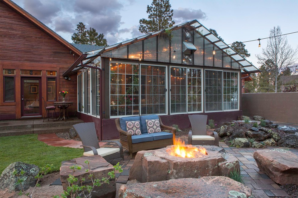 Inspiration for a large rustic backyard brick patio remodel in Phoenix with a fire pit and no cover