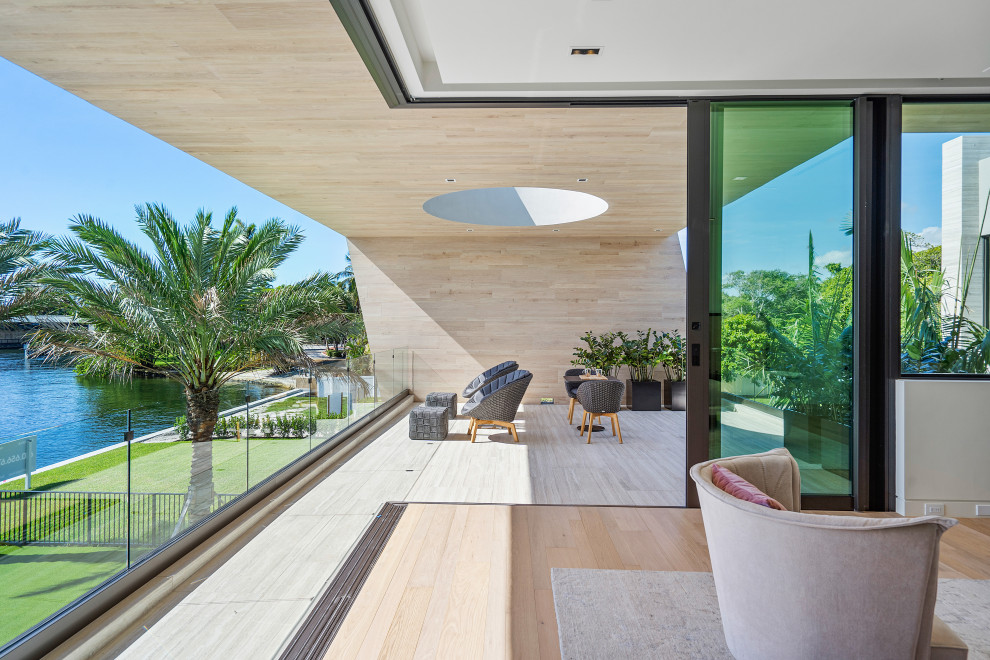 This is an example of an expansive contemporary sunroom in Miami with porcelain floors, a skylight and beige floor.