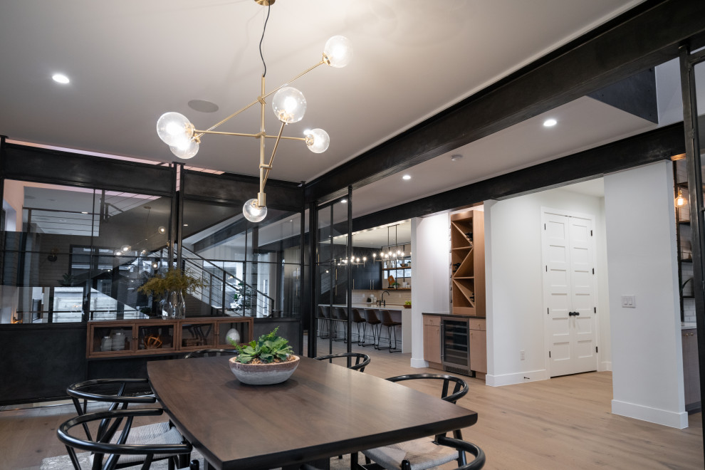 Ispirazione per una sala da pranzo moderna chiusa e di medie dimensioni con pareti bianche, pavimento in legno massello medio, pavimento marrone e pareti in mattoni