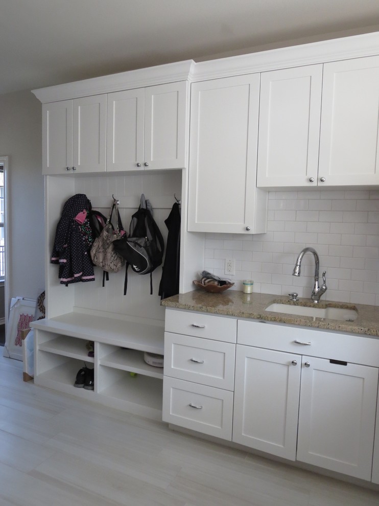 Mid-sized transitional l-shaped dedicated laundry room in Austin with a single-bowl sink, shaker cabinets, white cabinets, granite benchtops, beige walls, porcelain floors and a side-by-side washer and dryer.