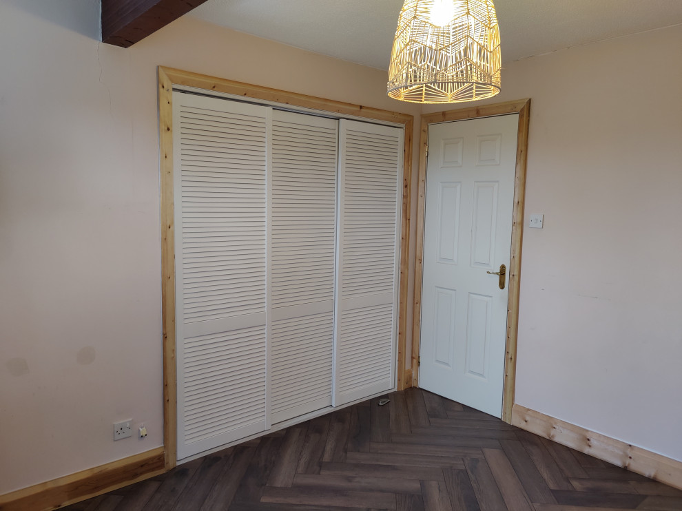Medium sized contemporary guest bedroom in Hampshire with laminate floors, no fireplace and brown floors.