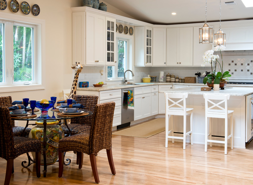 Inspiration for a transitional eat-in kitchen remodel in Miami with an undermount sink, white cabinets, white backsplash and stainless steel appliances