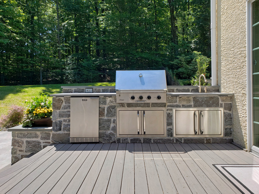 This is an example of a transitional metal railing outdoor kitchen porch design.