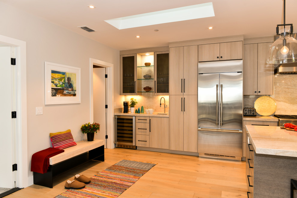 Design ideas for an expansive traditional galley open plan kitchen in San Francisco with a built-in sink, flat-panel cabinets, grey cabinets, quartz worktops, white splashback, marble splashback, stainless steel appliances, light hardwood flooring, an island, beige floors and white worktops.