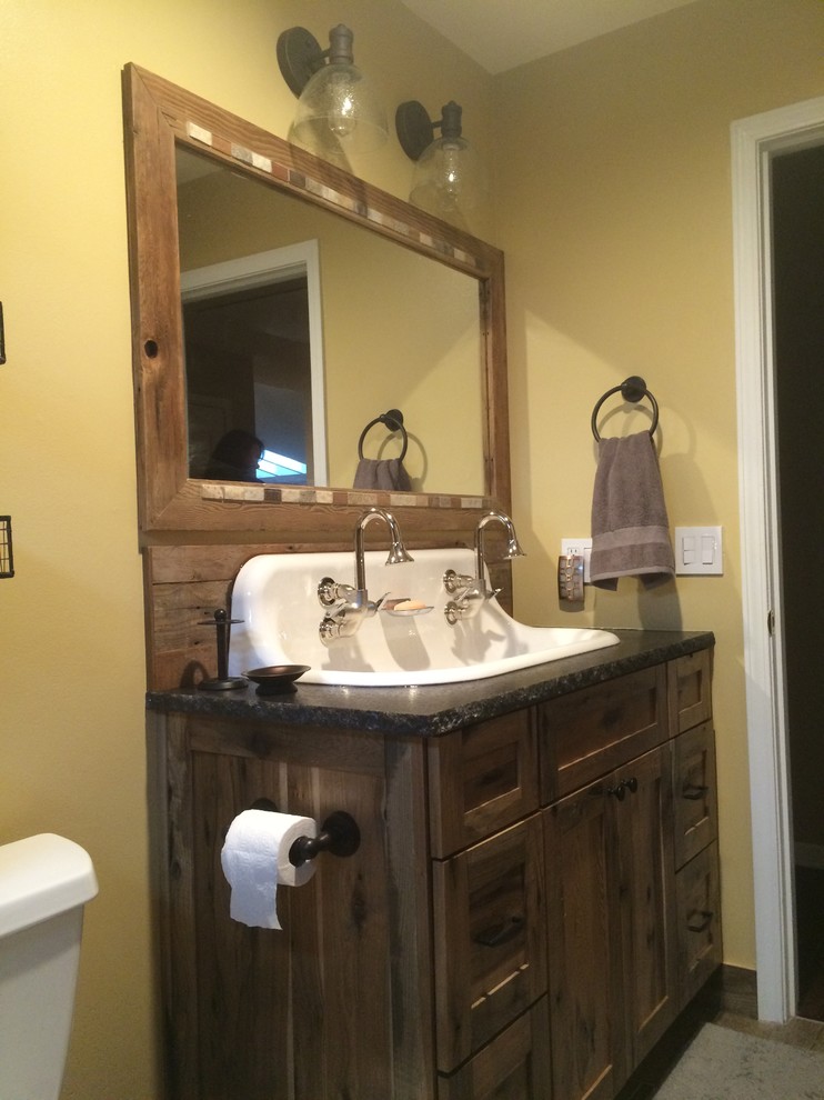 This is an example of a mid-sized country kids bathroom in Kansas City with a wall-mount sink, shaker cabinets, medium wood cabinets, granite benchtops, an alcove tub, a shower/bathtub combo, a two-piece toilet, brown tile, porcelain tile, beige walls and porcelain floors.