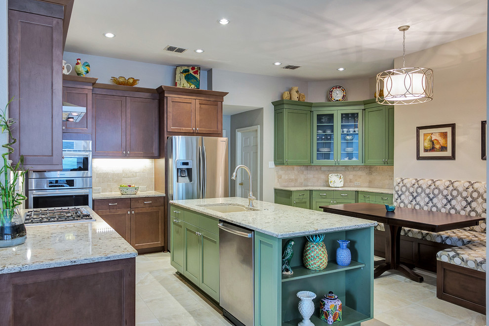 This is an example of a mid-sized traditional l-shaped eat-in kitchen in Dallas with an undermount sink, recessed-panel cabinets, medium wood cabinets, quartz benchtops, beige splashback, stone tile splashback, stainless steel appliances, travertine floors and with island.