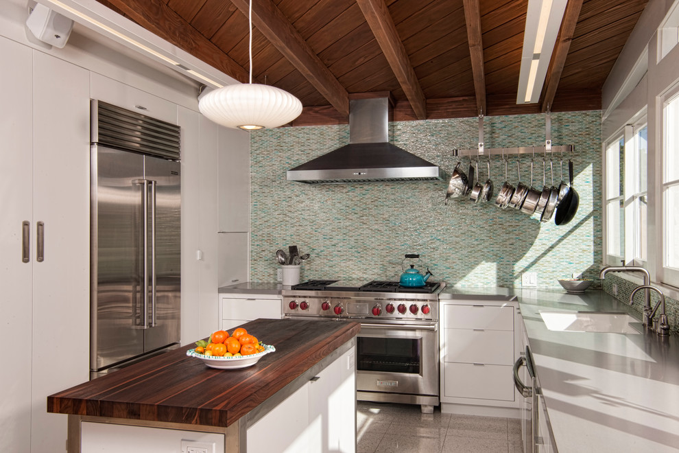 This is an example of a midcentury kitchen in San Diego with an undermount sink, flat-panel cabinets, white cabinets, multi-coloured splashback, mosaic tile splashback, stainless steel appliances, with island, marble benchtops and marble floors.