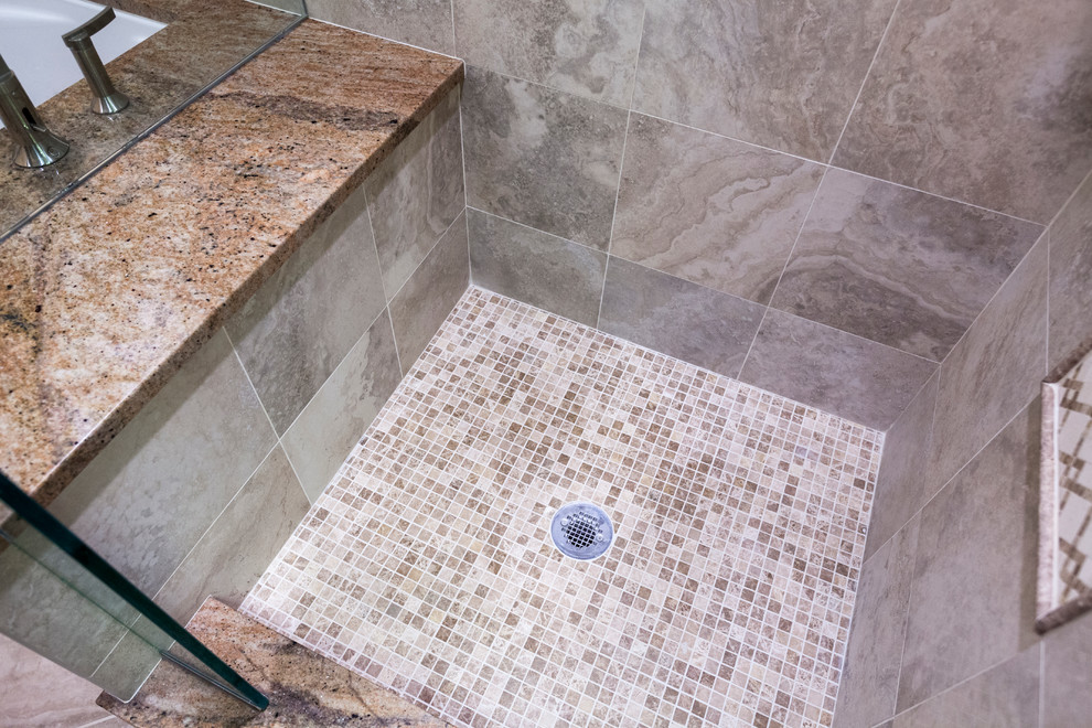 Photo of a mid-sized traditional master bathroom in Bridgeport with an undermount sink, raised-panel cabinets, medium wood cabinets, granite benchtops, an undermount tub, a shower/bathtub combo, a two-piece toilet, beige tile, porcelain tile, beige walls and porcelain floors.
