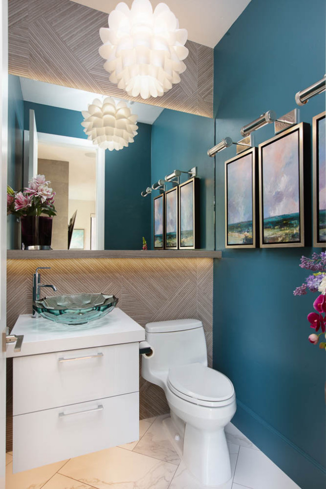 Inspiration for a small modern powder room in San Diego with flat-panel cabinets, white cabinets, blue walls, ceramic floors, a vessel sink, multi-coloured floor, white benchtops, a freestanding vanity and wallpaper.