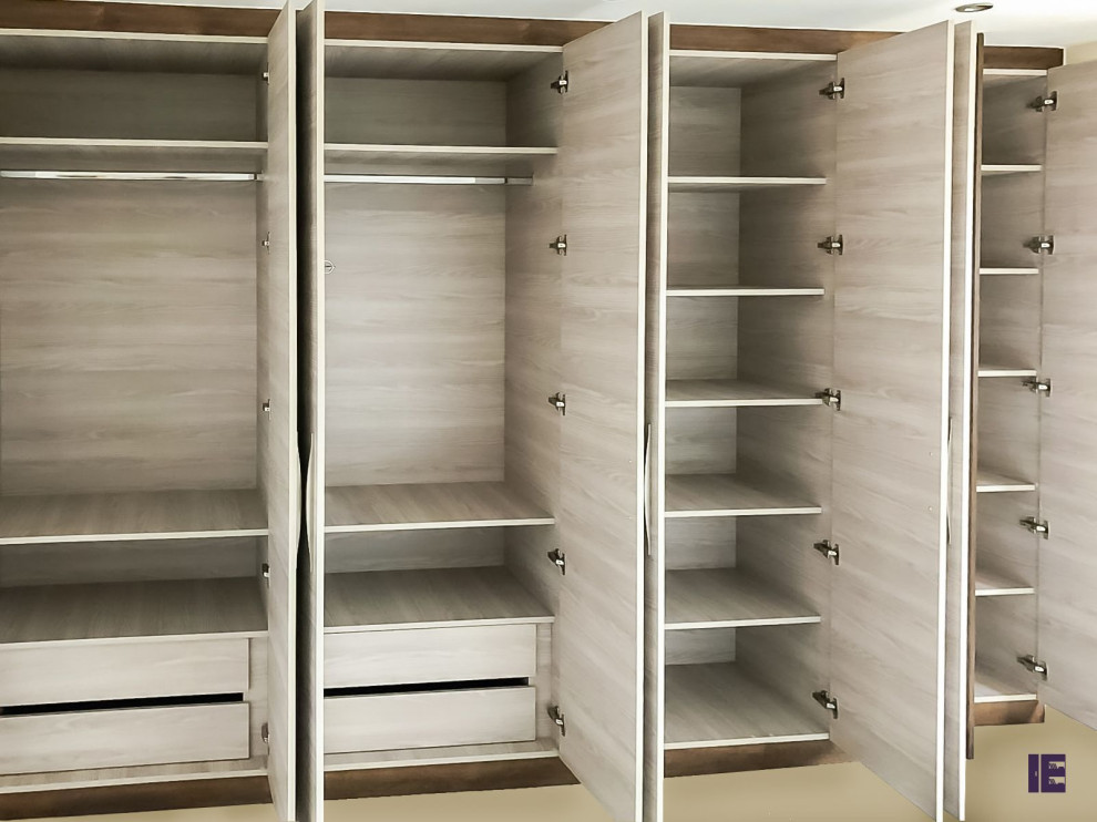 Large modern built-in wardrobe in London with flat-panel cabinets and medium wood cabinets.