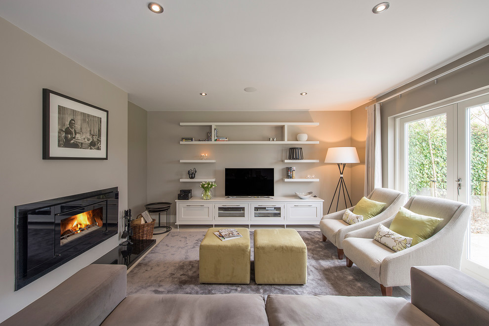 Photo of a transitional open concept living room in Dublin with grey walls, carpet, a freestanding tv and a ribbon fireplace.