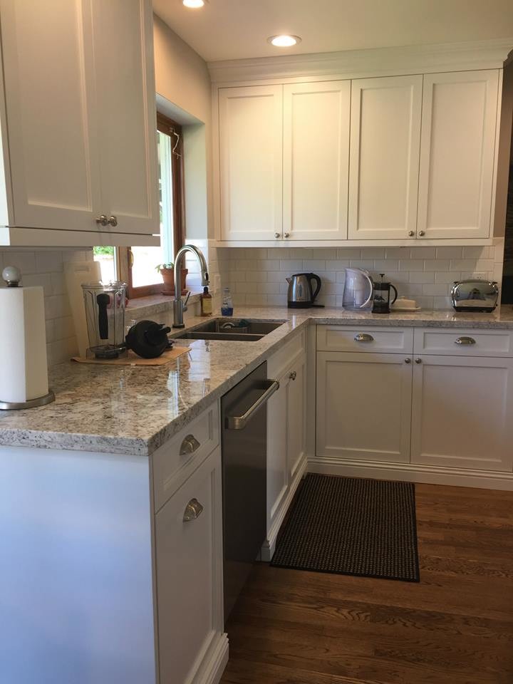Inspiration for a large transitional medium tone wood floor kitchen remodel in Phoenix with an undermount sink, shaker cabinets, white cabinets, granite countertops, white backsplash, subway tile backsplash, stainless steel appliances and an island