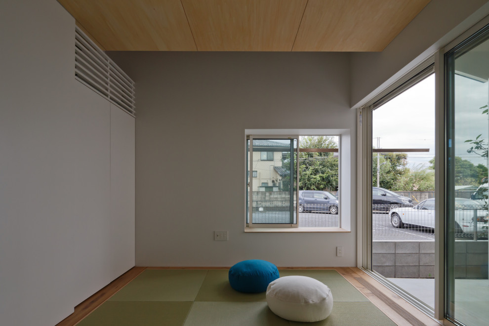This is an example of a small country master bedroom in Tokyo with white walls, tatami floors and green floor.