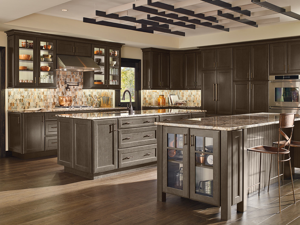 Design ideas for an expansive transitional kitchen in Indianapolis with dark wood cabinets, granite benchtops, multi-coloured splashback, stainless steel appliances, dark hardwood floors, multiple islands and brown floor.