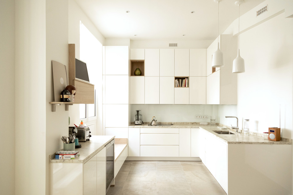 Inspiration for a large contemporary l-shaped kitchen in Other with an integrated sink, flat-panel cabinets, white cabinets, marble benchtops, white splashback, ceramic splashback, white appliances, ceramic floors, multiple islands, grey floor and white benchtop.