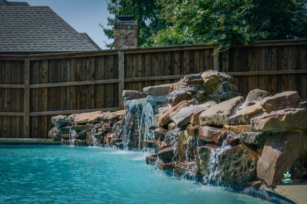 This is an example of a mid-sized backyard custom-shaped natural pool in Dallas with with privacy feature and stamped concrete.