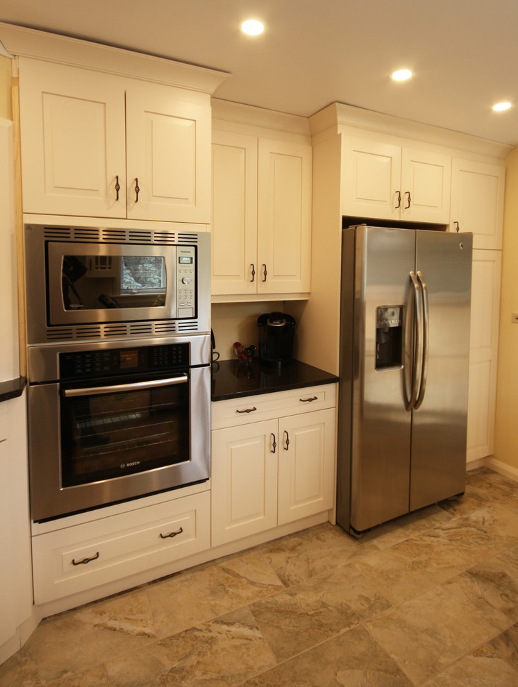 Small transitional porcelain tile enclosed kitchen photo in Ottawa with an undermount sink, raised-panel cabinets, white cabinets, granite countertops and stainless steel appliances