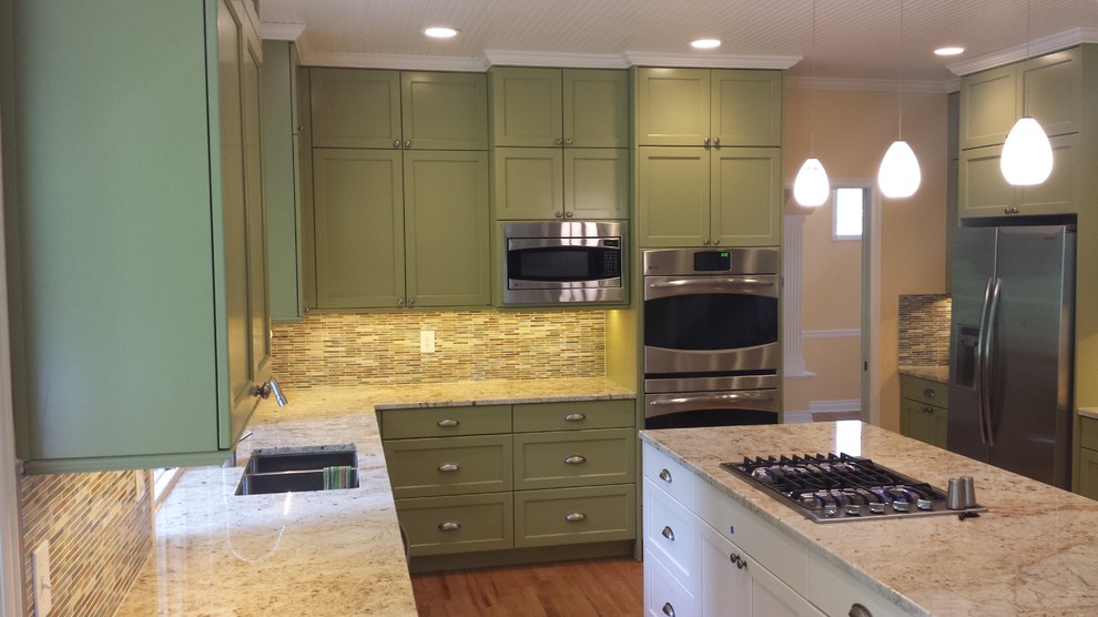 Example of a large transitional u-shaped medium tone wood floor kitchen design in Seattle with a double-bowl sink, recessed-panel cabinets, white cabinets, granite countertops, multicolored backsplash, mosaic tile backsplash, stainless steel appliances and an island