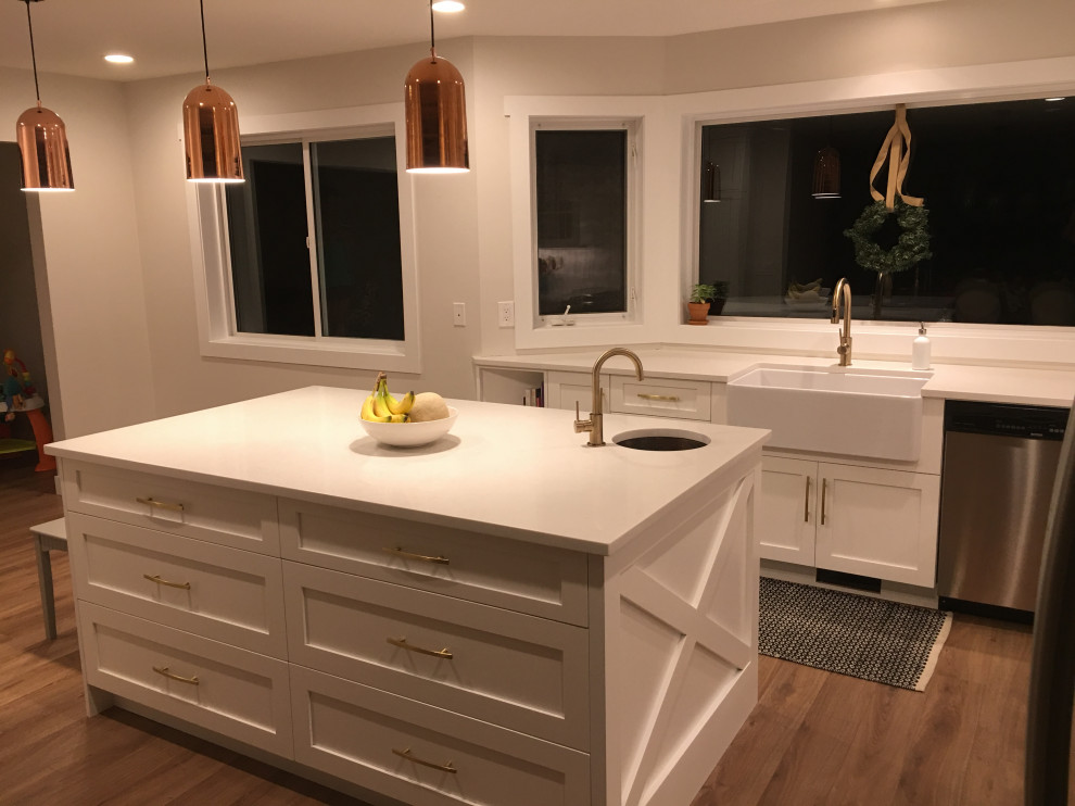 Eat-in kitchen - large transitional medium tone wood floor eat-in kitchen idea with a farmhouse sink, shaker cabinets, white cabinets, quartz countertops, stainless steel appliances, an island and white countertops