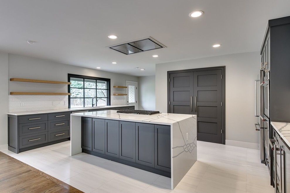 Photo of a large contemporary u-shaped open plan kitchen in Oklahoma City with an undermount sink, shaker cabinets, grey cabinets, quartzite benchtops, white splashback, ceramic splashback, stainless steel appliances, porcelain floors, with island, white floor and white benchtop.
