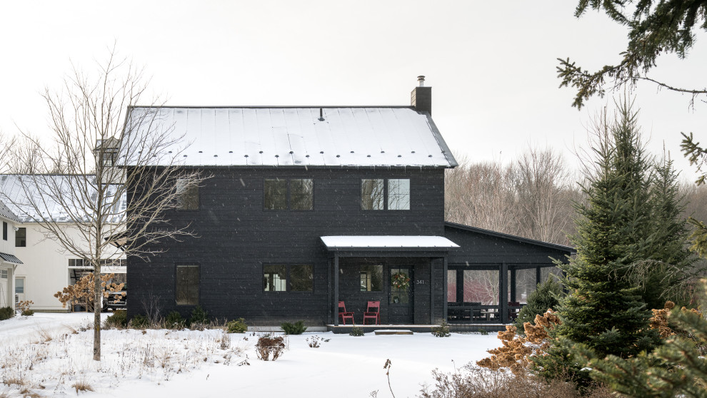 Example of a mid-sized danish black two-story wood gable roof design in Burlington with a metal roof and a gray roof