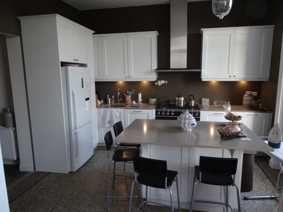 Photo of a mid-sized traditional l-shaped open plan kitchen in Marseille with an integrated sink, beaded inset cabinets, white cabinets, quartzite benchtops, brown splashback, black appliances, terrazzo floors, with island and beige benchtop.