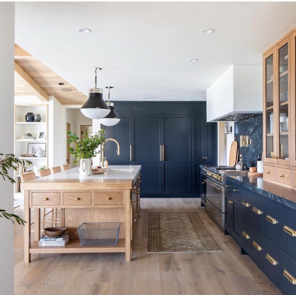 This is an example of a large l-shaped open plan kitchen in Dallas with an undermount sink, shaker cabinets, blue cabinets, marble benchtops, blue splashback, stone slab splashback, coloured appliances, light hardwood floors, with island, brown floor and multi-coloured benchtop.