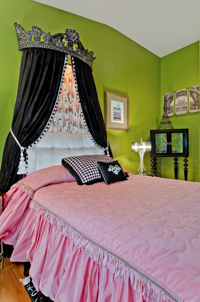 Small eclectic guest bedroom in Dallas with green walls and medium hardwood floors.