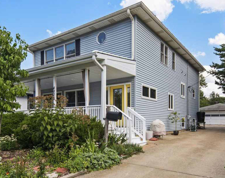 Mid-sized traditional blue two-story concrete fiberboard and clapboard house exterior idea in Chicago with a hip roof, a shingle roof and a gray roof