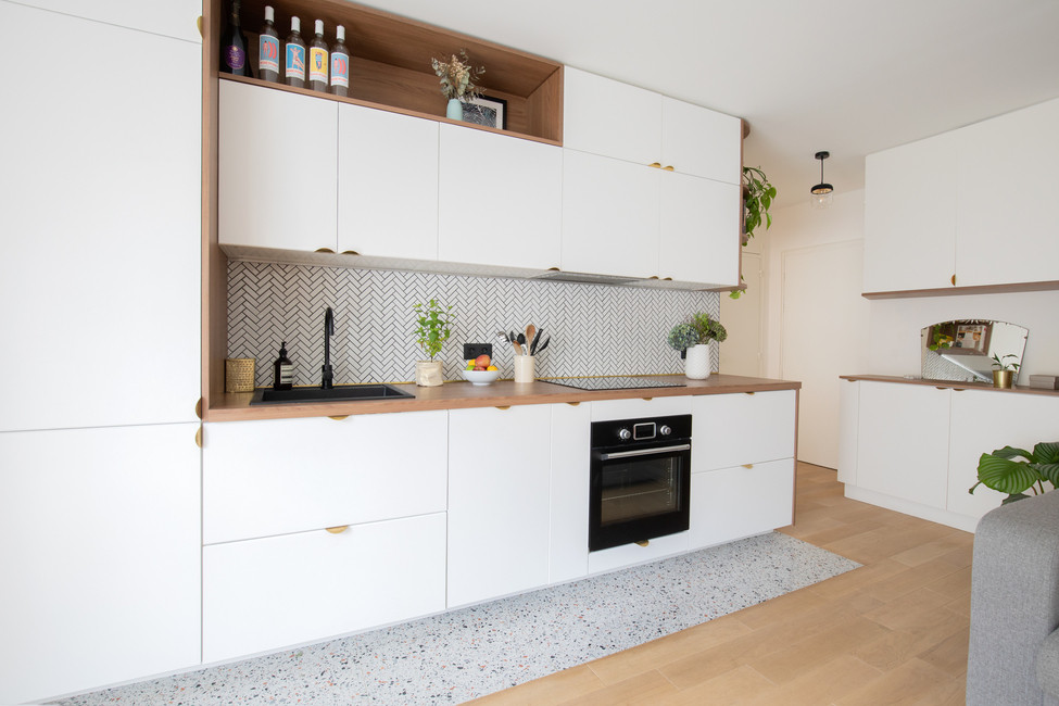 Design ideas for a mid-sized contemporary single-wall open plan kitchen in Paris with an undermount sink, beaded inset cabinets, white cabinets, wood benchtops, white splashback, ceramic splashback, panelled appliances, light hardwood floors, no island, beige floor and brown benchtop.