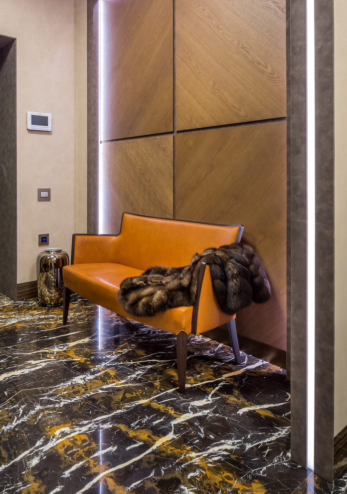 Photo of a mid-sized contemporary vestibule in Moscow with brown walls, marble floors and black floor.