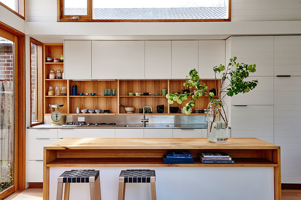Inspiration for a beach style kitchen in Geelong with an integrated sink, open cabinets, light wood cabinets, stainless steel benchtops, metallic splashback and with island.