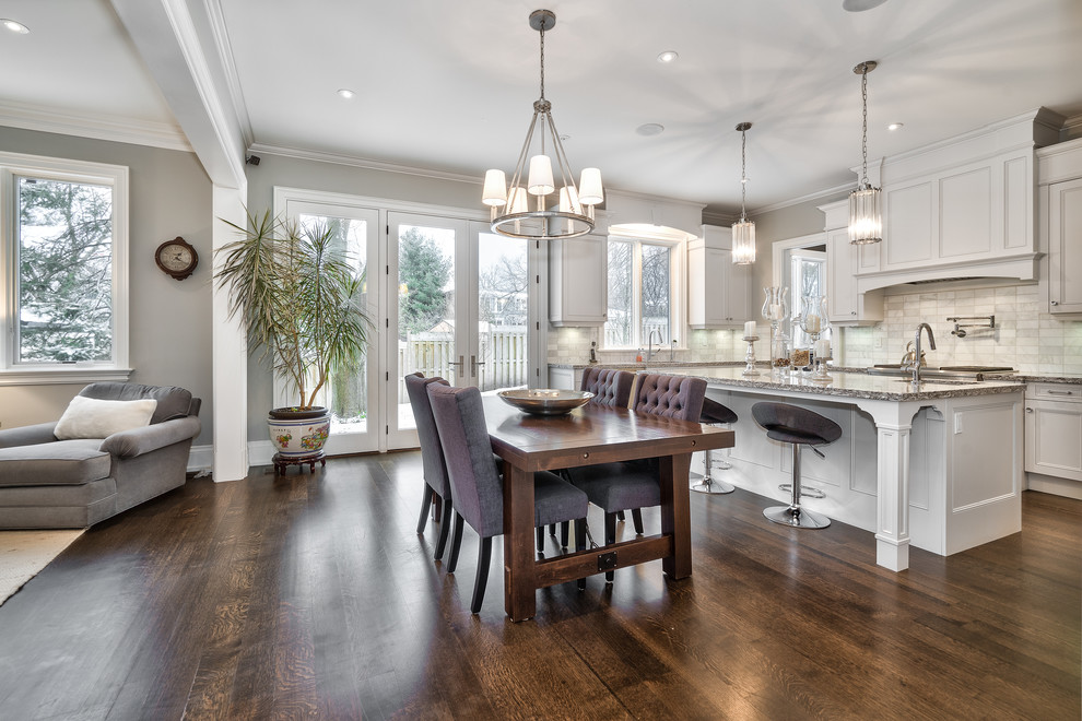 Open concept kitchen - large transitional u-shaped dark wood floor and brown floor open concept kitchen idea in Toronto with an undermount sink, beaded inset cabinets, white cabinets, granite countertops, gray backsplash, marble backsplash, paneled appliances, an island and multicolored countertops