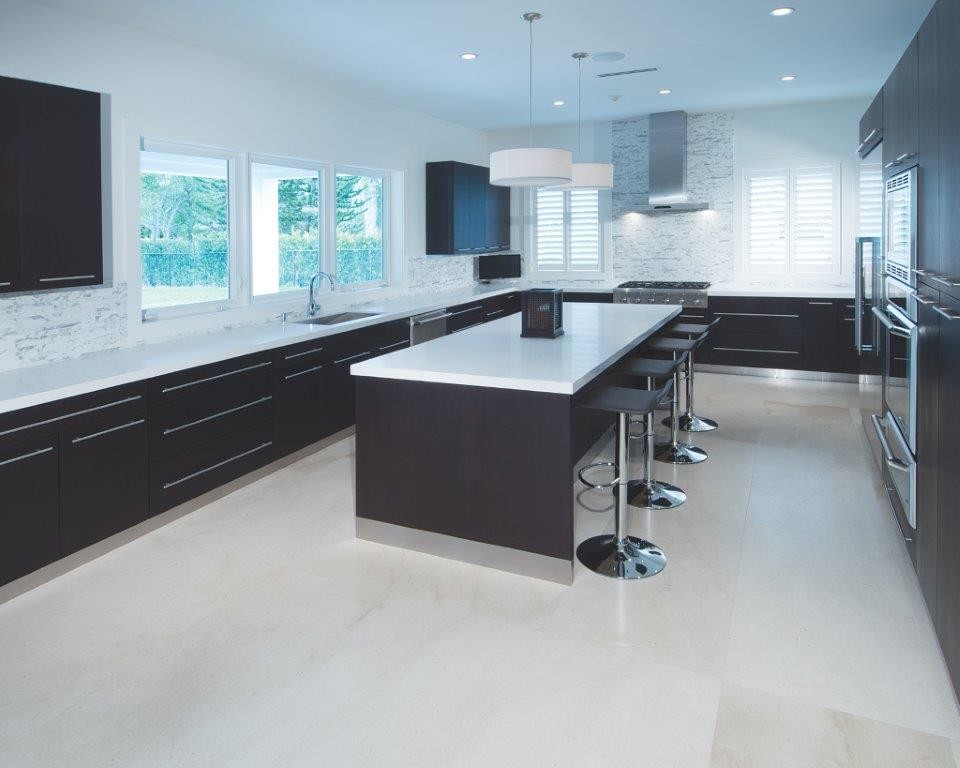 Inspiration for a large contemporary u-shaped eat-in kitchen in Miami with flat-panel cabinets, dark wood cabinets, quartz benchtops, white splashback, marble splashback, stainless steel appliances, limestone floors, with island and white floor.