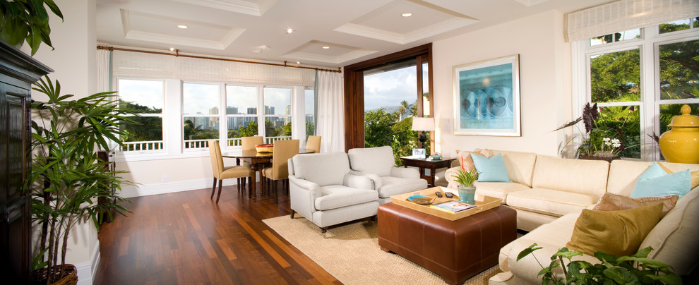 This is an example of a mid-sized tropical open concept family room in Hawaii with beige walls, dark hardwood floors, no fireplace and no tv.