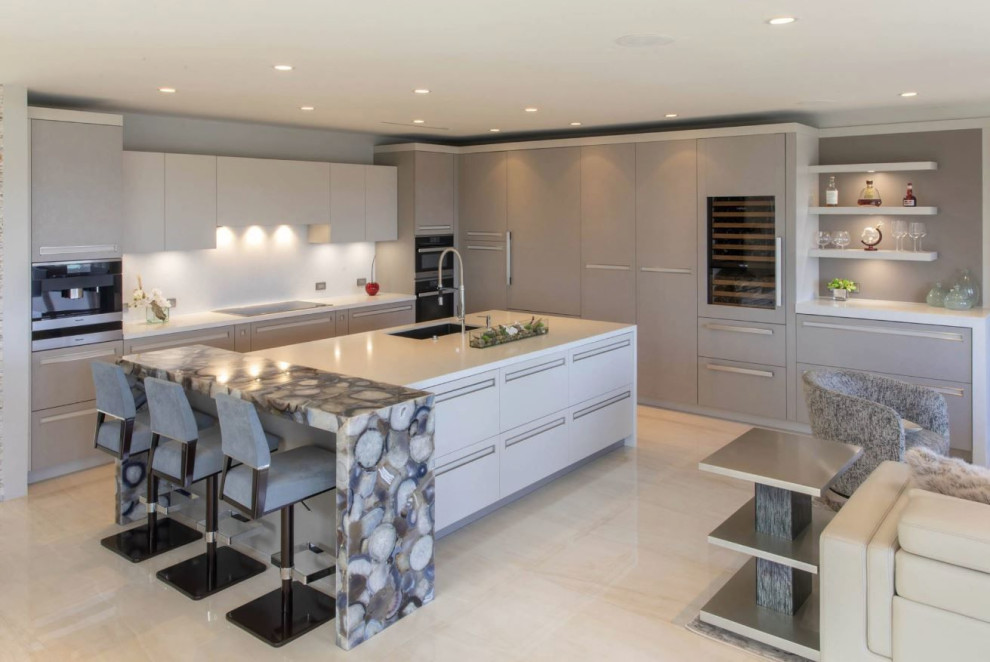 Photo of a mid-sized contemporary l-shaped open plan kitchen in Miami with a single-bowl sink, flat-panel cabinets, beige cabinets, quartzite benchtops, white splashback, engineered quartz splashback, panelled appliances, porcelain floors, with island, beige floor, blue benchtop and timber.