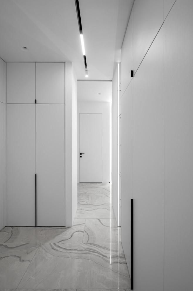 Свежая идея для дизайна: гардеробная комната среднего размера, унисекс в современном стиле с плоскими фасадами, белыми фасадами, полом из керамогранита и серым полом - отличное фото интерьера