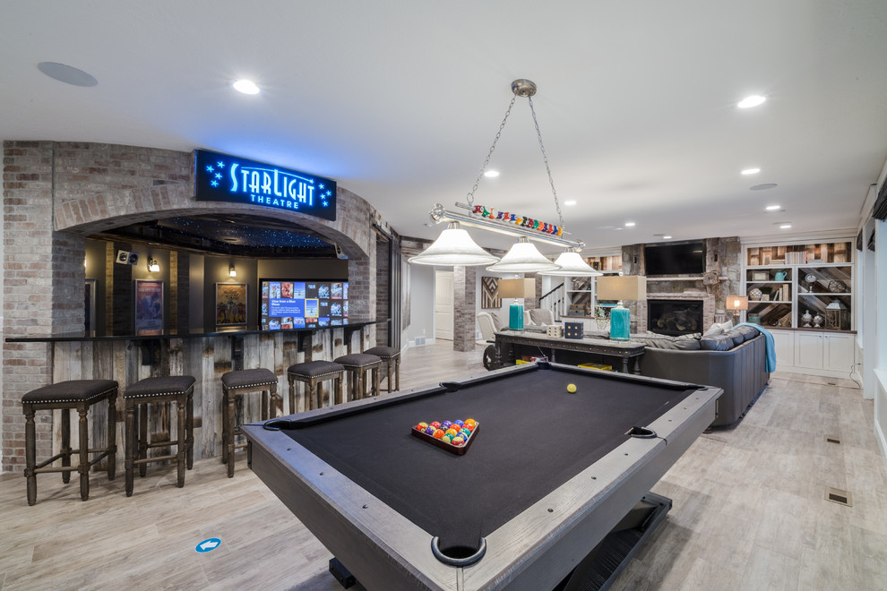 Design ideas for an expansive transitional walk-out basement in Salt Lake City with a game room, grey walls, medium hardwood floors, a standard fireplace, a brick fireplace surround and grey floor.