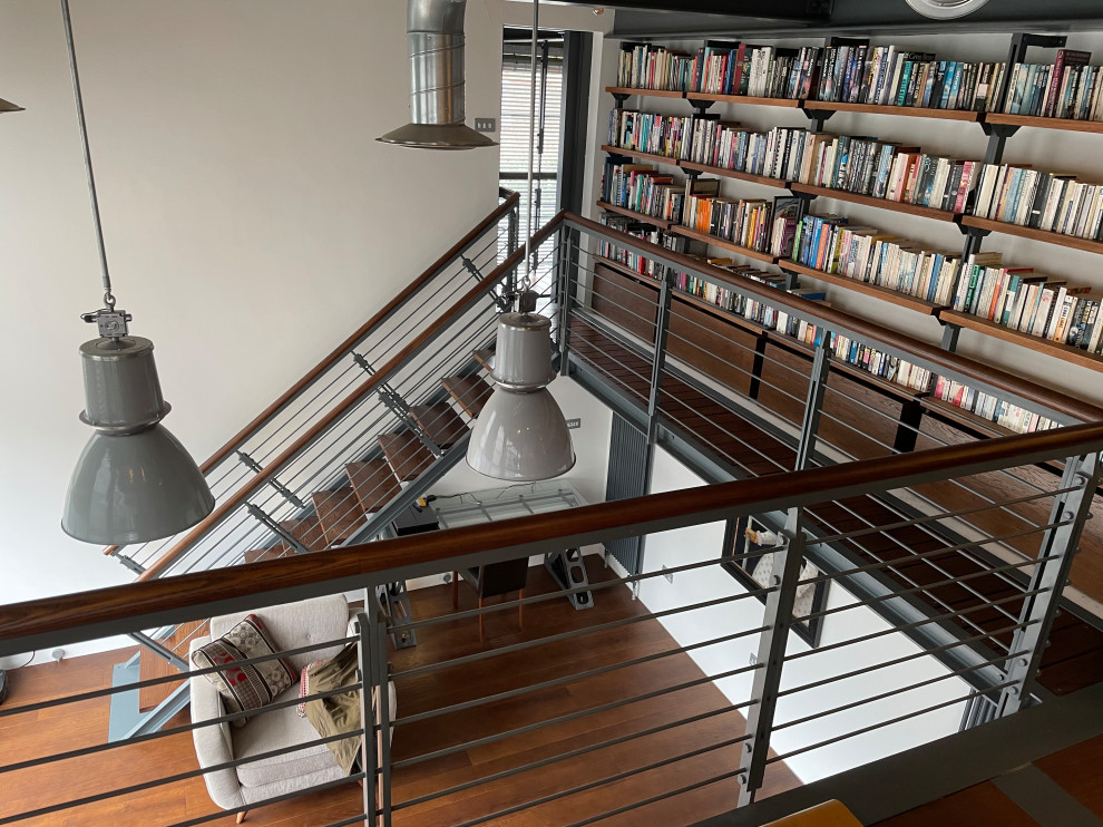 Cette image montre un escalier sans contremarche droit minimaliste de taille moyenne avec des marches en bois et un garde-corps en métal.