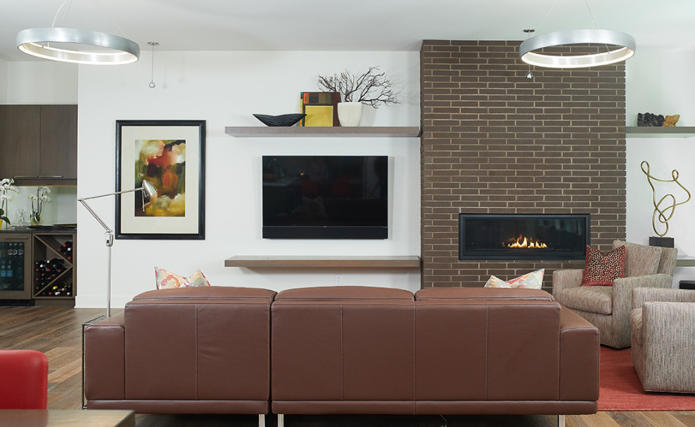 Design ideas for a midcentury open concept family room in Grand Rapids with white walls, dark hardwood floors, a ribbon fireplace, a brick fireplace surround, a wall-mounted tv and brown floor.