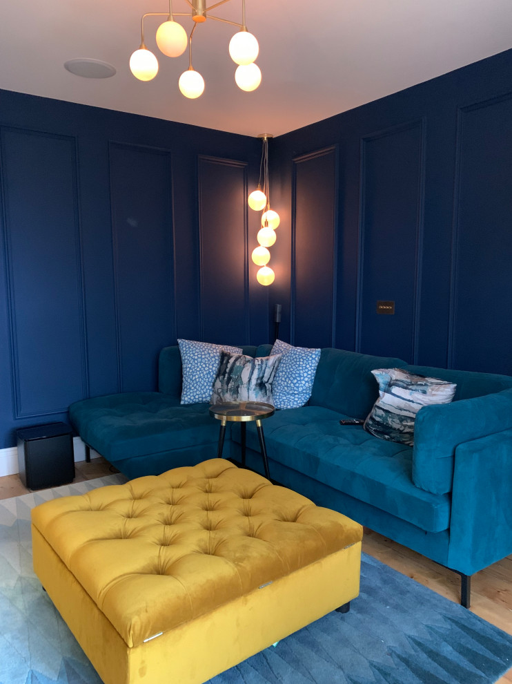 Idée de décoration pour un salon design de taille moyenne avec un mur bleu, parquet clair et une cheminée standard.